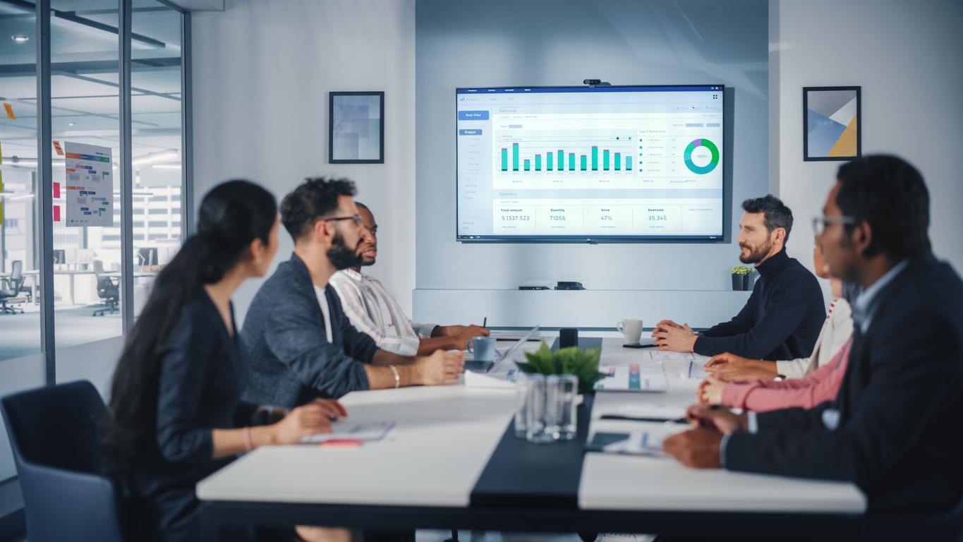 Multi-Ethnic Office Conference Room Meeting: Diverse Team of Managers, Executives Talk, Uses Wall TV with Big Data Analysis, Charts and Infographics. Businesspeople Investing in e Commerce Startup